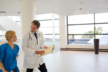 Naklejka na ściany i meble Doctor and nurse talking in hospital hallway