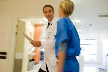 Naklejka na ściany i meble Nurse and doctor walking in hospital hallway
