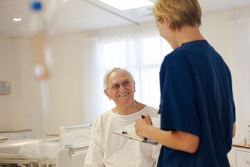 Obraz premium Nurse and older patient talking in hospital room