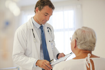 Doctor talking to older patient in hospital