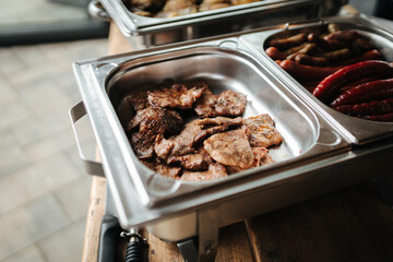 Steaks in a silver tray at a wedding buffet