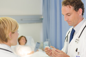 Obraz premium Doctor checking syringe in hospital room