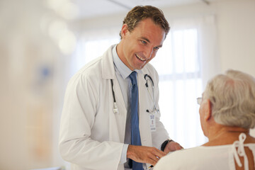 Obraz na płótnie Canvas Doctor talking to older patient in hospital