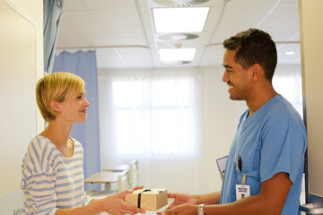 Patient giving nurse gift in hospital