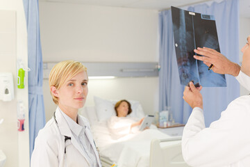 Obraz premium Doctors examining x-rays in hospital room