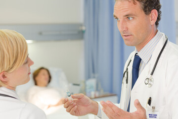 Fototapeta premium Doctor checking syringe in hospital room
