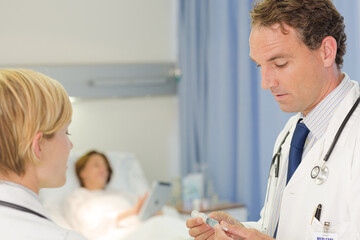 Fototapeta premium Doctor checking syringe in hospital room