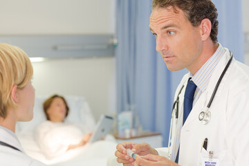 Obraz premium Doctor checking syringe in hospital room