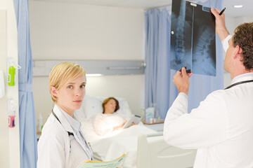 Obraz premium Doctors examining x-rays in hospital room