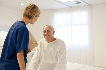 Nurse talking with older patient in hospital