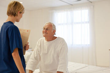 Obraz premium Nurse talking with older patient in hospital