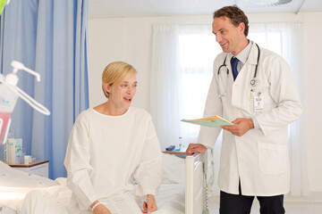 Fototapeta premium Doctor talking with patient in hospital room