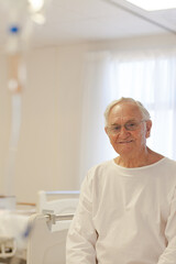 Older patient wearing gown in hospital room