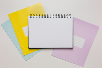 Notepad and exercise book on the desk. Mock up in copy space office on white background. Back to...