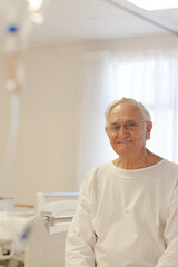 Older patient wearing gown in hospital room