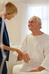 Fototapeta premium Nurse reading older patient's medical bracelet in hospital