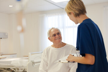 Obraz premium Nurse and older patient talking in hospital room