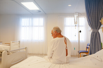 Obraz na płótnie Canvas Older patient wearing gown in hospital room