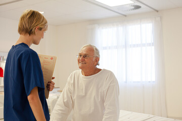 Nurse talking with older patient in hospital