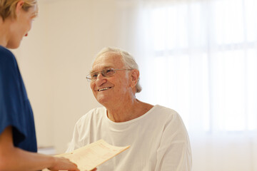 Nurse talking with older patient in hospital