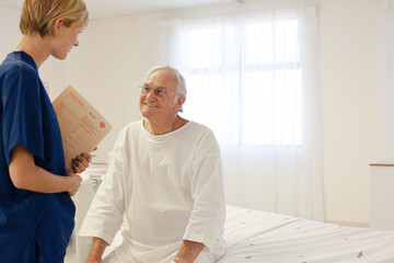 Nurse talking with older patient in hospital