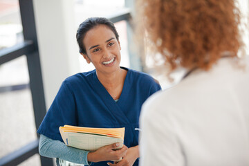 Doctor and nurse talking in hospital hallway