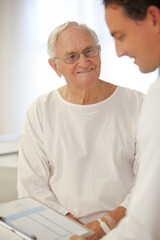 Doctor talking to older patient in hospital