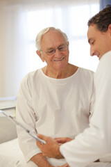 Doctor talking to older patient in hospital