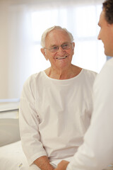 Fototapeta na wymiar Doctor talking to older patient in hospital