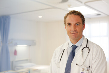 Doctor smiling in hospital hallway