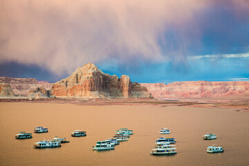 Houseboats on Glen Canyon and Powell Lake at sunset hours near the City of Page, Arizona, USA.