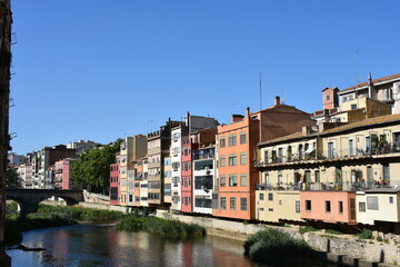 Naklejka na ściany i meble Puente en un rio con edificios de colores