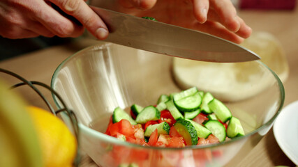 A young man is cooking a salat for his friend 