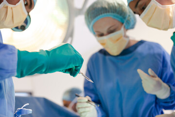 Surgeons bent over patient on operating table