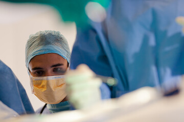 Surgeons bent over patient on operating table