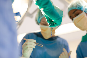 Surgeons bent over patient on operating table