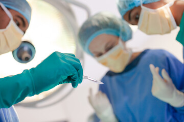 Surgeons bent over patient on operating table