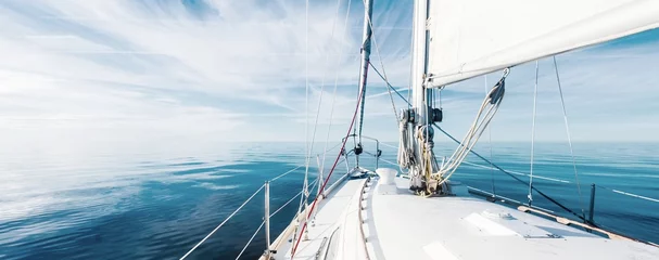Fotobehang White sloop rigged yacht sailing in an open Baltic sea on a clear sunny day. A view from the deck to the bow, mast and sails. Estonia © Aastels