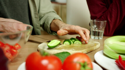 A young man is cooking a salat for his friend and talking