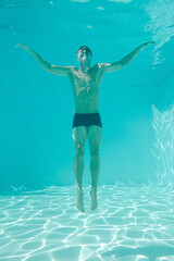 Man posing underwater in swimming pool