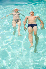 Obraz na płótnie Canvas Couple floating in swimming pool