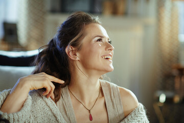 smiling female in modern living room in sunny winter day