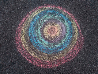 Fototapeta na wymiar Child asphalt chalk drawing of colorful rounds on old grunge asphalt sidewalk as textured background