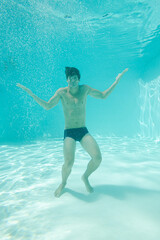 Man posing underwater in swimming pool