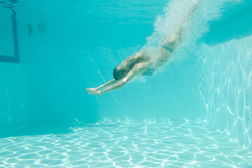 Woman swimming underwater in pool