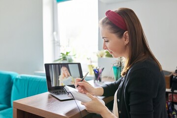 Female teacher at home with laptop on virtual meeting with teenage student
