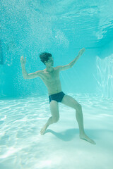 Man posing underwater in swimming pool