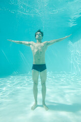 Man posing underwater in swimming pool