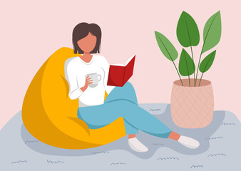 Young woman reading book on bag chair