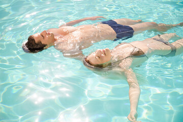 Couple floating in swimming pool